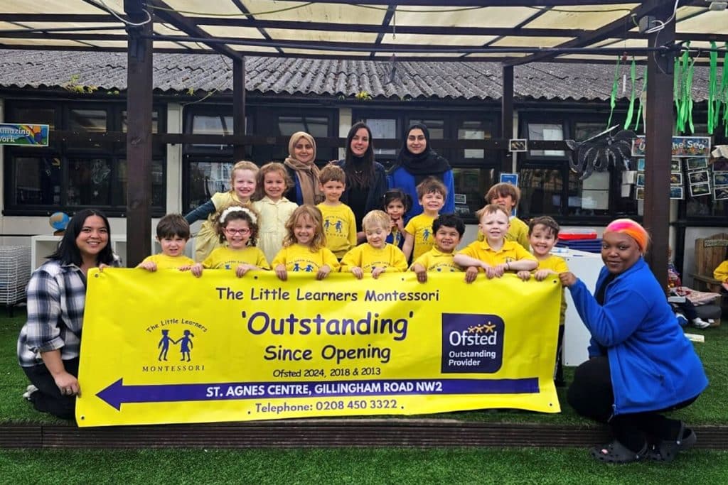 Children and staff from The Little Learners Montessori proudly displaying a banner that highlights their "Outstanding" Ofsted rating